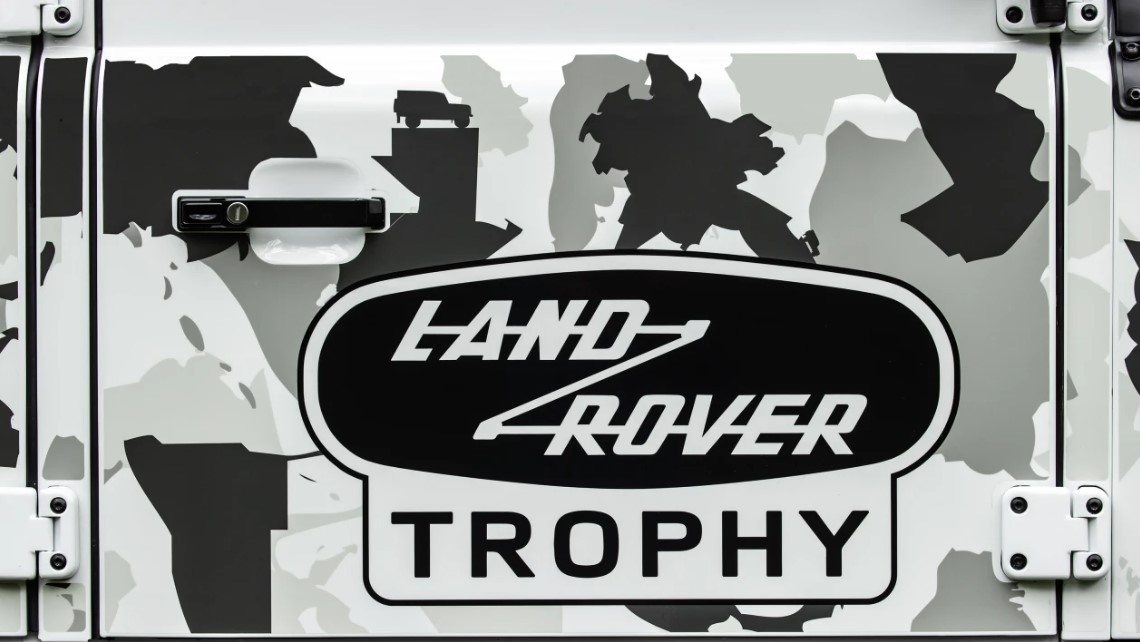 Land Rover изменил экстерьер, добавив защитную А-образную раму перед ветровым стеклом, в которой также находится лебедка, чтобы помочь Trophy II избежать неприятностей. Сатиново-черный капот предлагает больше, чем просто визуальную подсказку, посколь