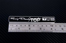 Алюминиевая эмблема TRD (Toyota Racing Development), черного цвета, с зеркальными буквами. Размер 110 * 17 мм.