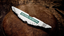 Новый значок разработан британским арт-директором и графическим дизайнером Питером Сэвиллом. Физическая форма изготовлена вручную ювелирами в Бирмингеме. Впервые с 2003 года логотип был изменен, и, чтобы отметить это событие, Aston Martin продемонстр