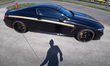 Тестовый автомобиль представляет собой машину, покрытую черной краской с золотыми гоночными полосами по центру и бокам.